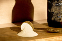Product packaging with a scoop of powder on a wooden surface