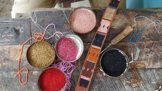Sustainable and Ethical Practices Aspiga - pots of beads on a table creating decorated belts