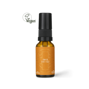 A brown bottle labeled “True Vitamin D3 + K2” by Ancient + Brave, featuring a black spray cap and a vibrant orange label, stands upright to showcase its potent Vitamin D3 spray for bone support. A green vegan symbol is visible in the top left corner against the plain white background.