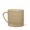 A beige ceramic Ritual Mug by Ancient + Brave, featuring a simple, natural texture and an unfinished, slightly darker base, displayed against a plain white background.