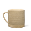 The Matcha Mug Gift Set features a handmade beige ceramic mug with a rounded shape, large handle, and unglazed textured base—ideal for enjoying your morning matcha or wellness drinks—shown on a plain white background.