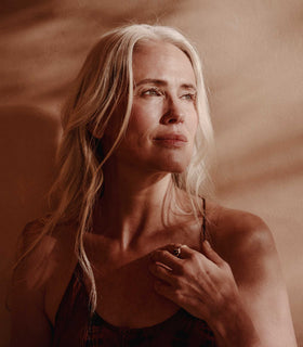 Woman with blonde hair against a warm-toned background