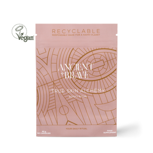 Ancient + Brave True Skin Alchemy Beauty Ritual supplement pouch in a dusty pink color with gold line art patterns, shown on a white background with a Vegan logo overlay.