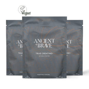 Three stand-up pouches of Ancient + Brave True Creatine+ arranged in a fan shape against a solid black background, with a Vegan logo at the top left.