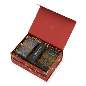 An open red gift box containing a Davina Ritual Gift Set, with two boxes of dietary supplements and a long, narrow container labeled The Ritual Scoop nestled in gold paper filler.