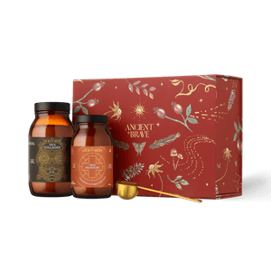 Two amber jars of Ancient + Brave collagen peptides and a gold measuring spoon positioned in front of a decorative red Rest Gift Set box.