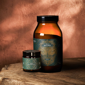 Two jars labeled 'True Biome' and 'True Magnesium' on a wooden surface with a warm brown background
