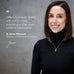 A smiling woman with shoulder-length brown hair wears a black turtleneck and a delicate gold necklace with a small oval pendant, set against a textured gray background with a quote by Dr. Jenna Macciocchi.