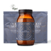 An amber glass bottle of Ancient + Brave's True Hydration electrolyte formula centered in front of two blue pouches, with a small Vegan logo above on a black background.