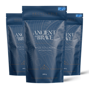 Three blue stand-up pouches of Ancient + Brave's Wild Collagen arranged in a fan shape against a black background. The center pouch is fully visible, with two partially visible pouches on each side.