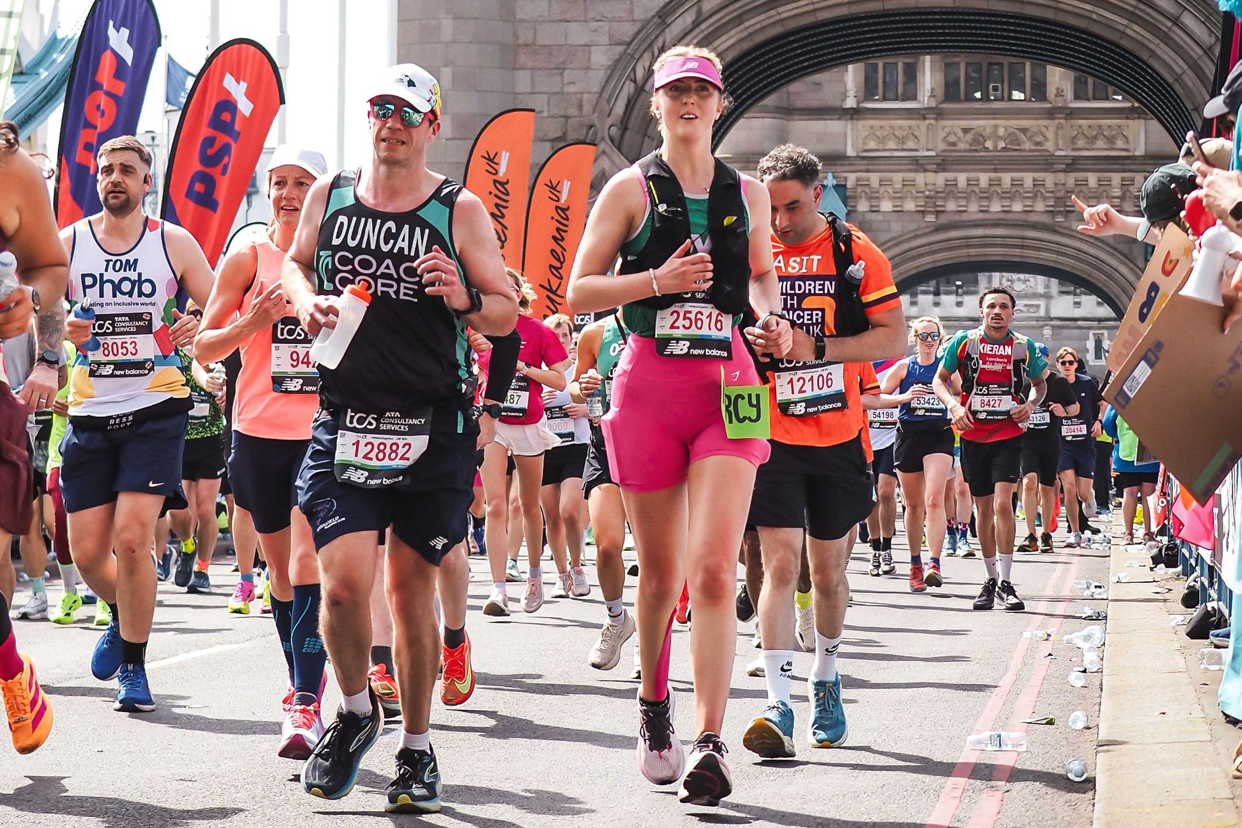 Runners participating in a marathon with a prominent arch in the background